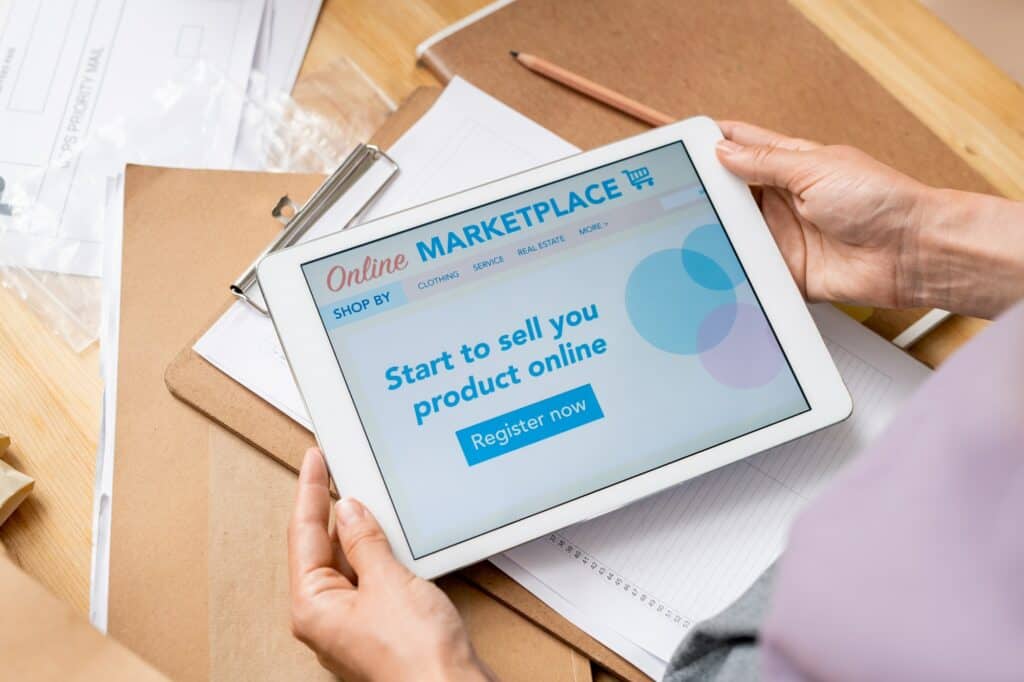 Hands of contemporary female manager of online shop with touchscreen